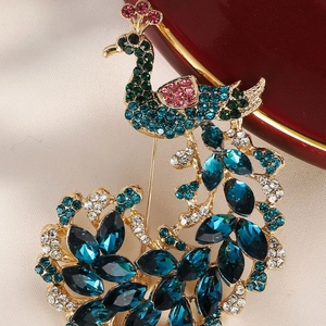 Elegant gold peacock brooch featuring colorful crystals and vibrant sparkling gemstones