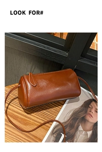 Brown cylindrical leather crossbody bag detail shot, vintage style daily shoulder purse.