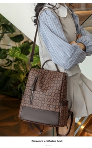 Detail view of vintage brown printed backpack with top handle and front zipper pocket