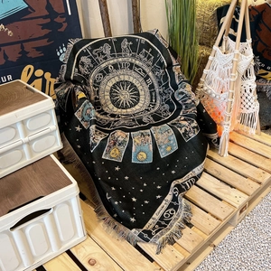 Close-up of woven bohemian blanket with zodiac patterns and decorative tassel fringe