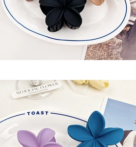 Close-up of matte flower hair claws in multiple colors like black, purple, and blue