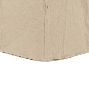 Détail de l'ourlet et des boutons d'une chemise en lin avec texture de tissu beige naturel