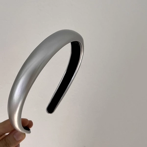 Detail of silver metallic headband showing smooth texture and high-gloss finish