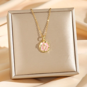 Collier avec pendentif tulipe doré de luxe posé sur une boîte à bijoux et du satin