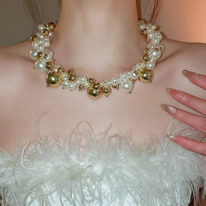 Detail shot of irregular pearl necklace with gold beads on elegant collarbone