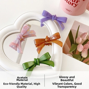 Detail of colorful acetate bow hair clips on a mirror showing France Handmade logo