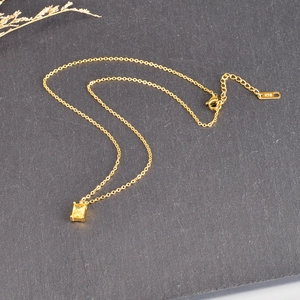 Detail of 18K gold-plated square emerald pendant on a stainless steel chain necklace