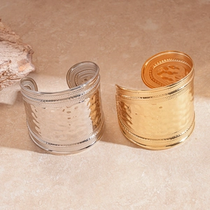 Wide hammered metal cuff bracelets in gold and silver finish with bohemian wave patterns