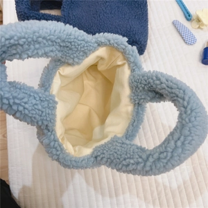 Vue de dessus du mini sac en laine d'agneau bleue montrant la texture et la doublure blanche