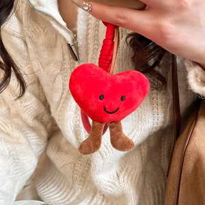 Detail showing the red plush heart pendant with black embroidered smile and soft texture