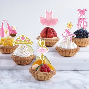 Close-up of ballet-themed cupcake toppers featuring pink shoes and golden crowns