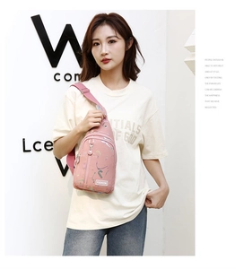 Close-up of pink crossbody sling bag with colorful ink splatter and FASHION patch