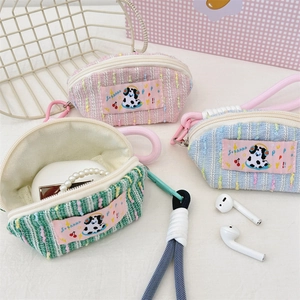 Close-up of colorful woven headphone cases with dog labels and smooth white zippers