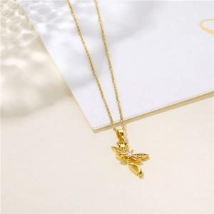 Elegant gold dragonfly necklace with sparkling zircons set against soft natural shadows
