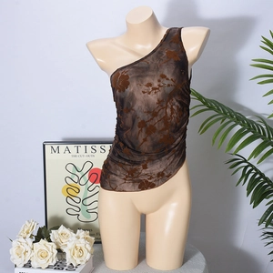 Detail of brown floral sheer mesh one-shoulder top on display with artistic background