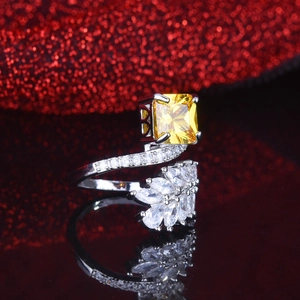Detailed close-up of radiant cut yellow diamond ring with marquise side stones