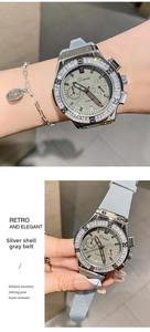 Detail of silver watch case with rhinestone bezel and textured grey silicone strap
