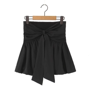 Detail of black strapless tube top featuring a large front bow and elastic smocked back