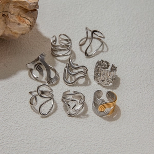 Detailed view of 8-piece silver steel rings with liquid metal and hammered texture