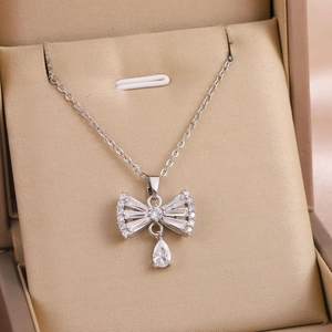Collana a fiocco in argento con zirconi a goccia su una scatola di seta elegante