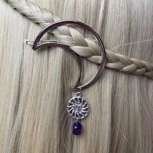 Silver crescent moon hair clip with sun totem and purple gemstone on blonde braided hair