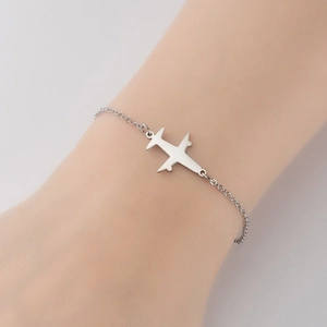 Polished silver stainless steel airplane charm bracelet worn on wrist for travel style