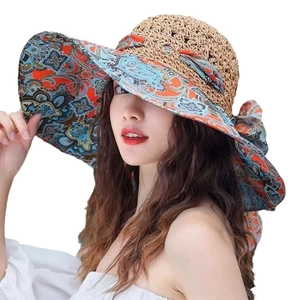 Women's wide brim straw sun hat with ethnic floral lining and decorative bow detail