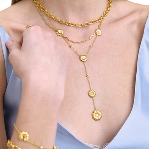 Gros plan d'un collier marguerite 18K à double couche serti de zircons blancs