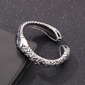 Macro shot of hip hop snake ring with green stone eyes and detailed scale texture