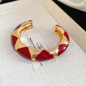 Macro shot of red enamel and gold-plated geometric triangle pattern on vintage open bangle