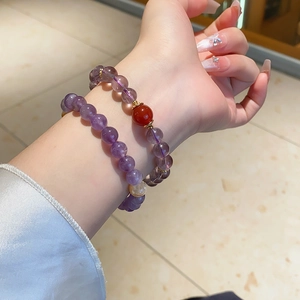 Detail of natural purple amethyst beads and yellow crystal bracelet set on female wrist