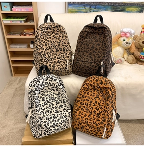Macro detail of leopard print corduroy backpacks in beige, coffee, and orange tones