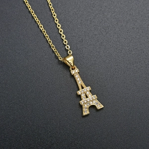 Detailed view of a gold Eiffel Tower pendant necklace encrusted with white cubic zirconia