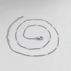 Detailed macro view of silver stainless steel chain with lobster clasp and extender
