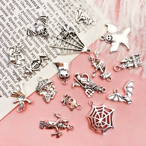 Close-up of vintage silver Halloween skull and ghost charms for DIY jewelry making