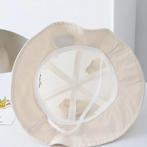 Detail view of breathable white mesh lining and elastic chin strap on the beige panda sun hat