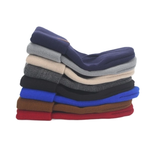 Stack of various colorful knitted wool beanies providing stylish and cozy winter warmth