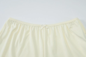 Détail du short en maille côtelée jaune clair avec taille élastique et nœud décoratif