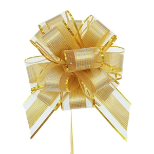 Detailed view of white and gold textured mesh pull bow for festive gift wrapping
