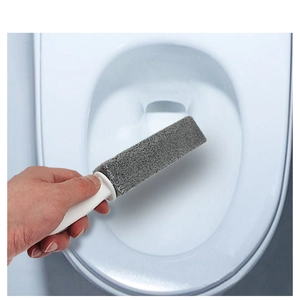 Détail d'une brosse de toilette en pierre ponce nettoyant les taches sur la céramique