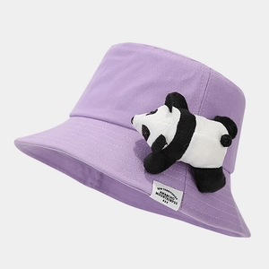 Detail of cute panda plush doll and logo label on purple cotton bucket hat
