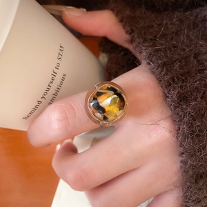 Close-up of vintage resin leopard print ring with gold trim on a model hand