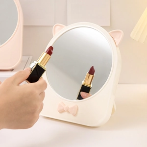 Specchio da trucco rotondo bianco con orecchie da gatto e fiocco in uso quotidiano