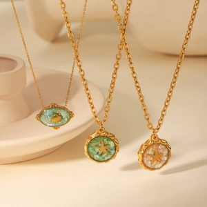 Detail of 18K gold starfish shell pendants with colorful crushed sea shell inlay