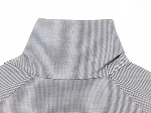 Close-up of the grey plaid turtle neck collar with fine knit fabric texture