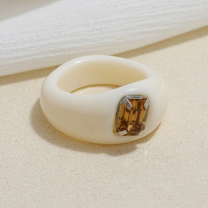 Detailed close-up of retro cream resin ring with an amber rectangle gemstone inlay