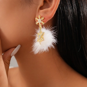 Detail of Christmas snowflake earrings with rhinestones and white fur balls on model