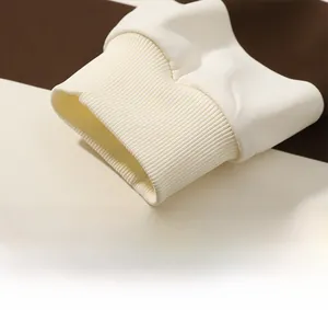 Gros plan détaillé des poignets côtelés et du tricot à rayures marron du polo manches longues