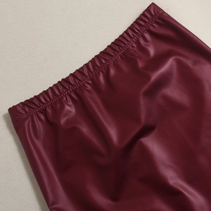 Detailaufnahme des elastischen Faltenbunds an diesem tief weinroten Kunstlederrock