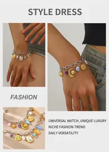 Detail of stainless steel charm bracelet with star, moon and tulip oil-drop pendants
